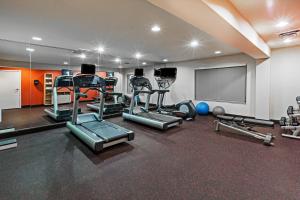 a gym with several tread machines and a screen at TownePlace Suites by Marriott Odessa in Odessa