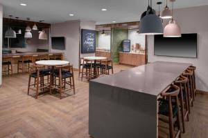 una cucina con tavoli e sgabelli in un ristorante di Fairfield Inn & Suites by Marriott Roanoke Salem a Salem