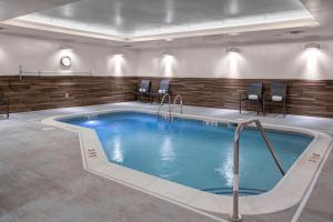 a pool in a hotel room with chairs around it at Fairfield Inn & Suites by Marriott Roanoke Salem in Salem