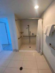 a bathroom with a shower and a tiled floor at Elegance in Miami Beach, Kitchen & Views -A in Hallandale Beach