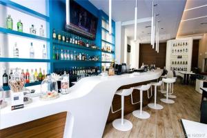 a bar with a white counter and bar stools at Elegance in Miami Beach, Kitchen & Views -A in Hallandale Beach