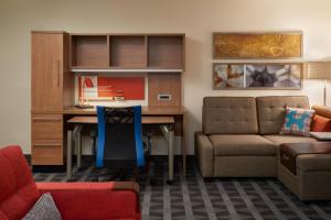 a living room with a desk and a couch and a chair at TownePlace Suites by Marriott Windsor in Windsor