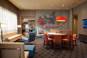 a lobby with a dining area with a table and chairs at TownePlace Suites by Marriott Windsor in Windsor