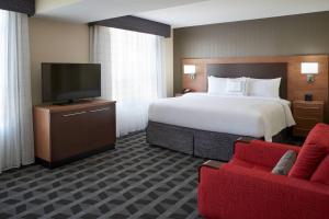a hotel room with a bed and a flat screen tv at TownePlace Suites by Marriott Windsor in Windsor