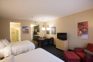 a hotel room with two beds and a dining room at TownePlace Suites by Marriott Lincoln North in Lincoln