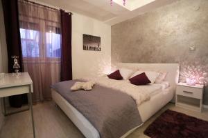 a bedroom with a bed with a teddy bear on it at Sfinga apartment in Zadar