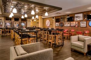 a restaurant with tables and chairs and a bar at Four Points by Sheraton Louisville Airport in Louisville