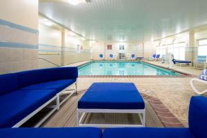 a large swimming pool with blue chairs at Four Points by Sheraton Louisville Airport in Louisville