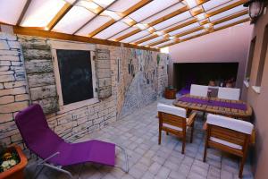 a patio with a table and chairs and a stone wall at Sfinga apartment in Zadar