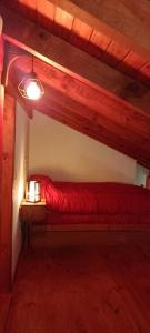 1 dormitorio con 1 cama roja en una habitación en Cabaña Miralopez en San Carlos de Bariloche