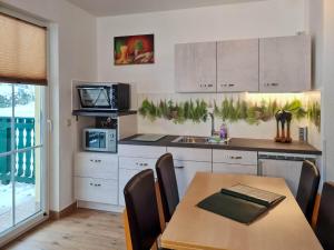 a kitchen with a wooden table and a dining room at Ferienanlage Zum Wildbach Schierke in Schierke