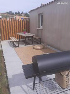 a backyard with a picnic table and a bench at Agréable petite maison in Vagnas