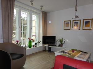 a living room with a red couch and a tv at Meeresleuchten in Lüneburg