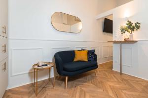 uma sala de estar com uma cadeira azul e um espelho em Charming studio - in the downtown em Budapeste