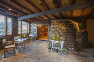 Habitación con un edificio de piedra con mesas y sillas en Lyhnos, en Askas