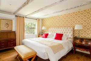 a bedroom with a large white bed with red pillows at Su Paradise Chalés e Suítes in Itaipava