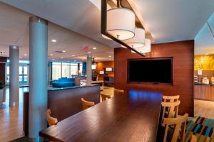 a dining room with a large wooden table and a flat screen tv at Fairfield Inn & Suites by Marriott Dallas Waxahachie in Waxahachie