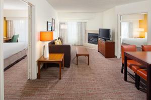 ein Hotelzimmer mit einem Bett und einem Wohnzimmer in der Unterkunft Residence Inn Houston - West University in Houston