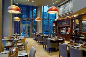 ロンドンにあるMarriott Executive Apartments London, Canary Wharfのテーブルと椅子のあるレストラン、バー