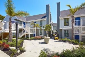 a large building with palm trees and a courtyard at Residence Inn Los Angeles LAX/Manhattan Beach in Manhattan Beach