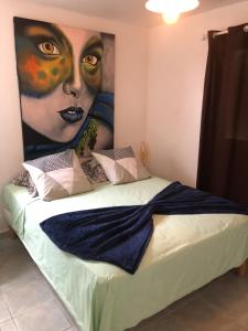 a bedroom with a large painting of a woman at LEN'HOUSE in Oyster Pond