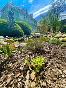 a garden in front of a large house at A l'Ombre des tilleuls in Husseren-Wesserling