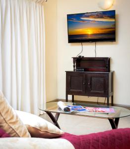 a living room with a coffee table and a flat screen tv at ZenBreak Golden View #115 in Saint James