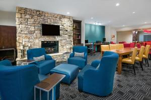 a waiting room with blue chairs and a fireplace at TownePlace Suites by Marriott San Antonio Northwest in San Antonio