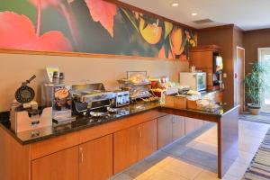 a kitchen with a counter with a counter top with food at Fairfield Inn and Suites by Marriott Elk Grove in Elk Grove