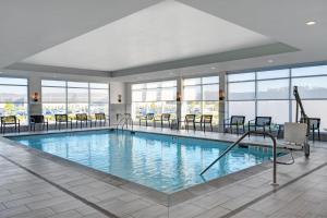 a pool in a hotel with chairs and windows at Courtyard by Marriott Hamilton in Hamilton