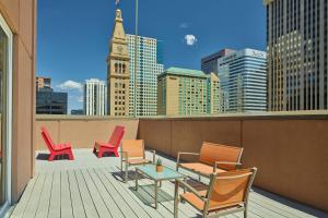 balkon z krzesłami, stołem i wieżą zegarową w obiekcie Courtyard by Marriott Denver Downtown w mieście Denver