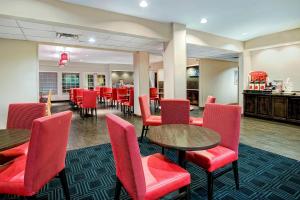 un restaurante con mesas y sillas rojas y un bar en TownePlace Suites by Marriott San Antonio Northwest, en San Antonio