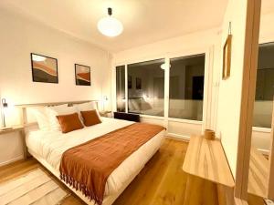 ein Schlafzimmer mit einem großen Bett und einem großen Fenster in der Unterkunft Appartement - Lit Queen Size - Proximité Genève in Saint-Julien-en-Genevois