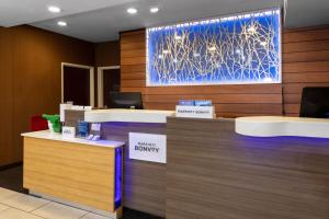 a lobby with a reception desk with a large painting on the wall at Fairfield Inn Tallahassee North/I-10 in Tallahassee