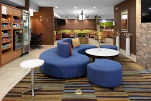 a lobby with blue chairs and tables in a store at Fairfield Inn Tallahassee North/I-10 in Tallahassee