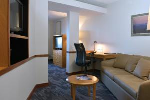 a living room with a couch and a desk at Fairfield Inn & Suites Indianapolis East in Indianapolis