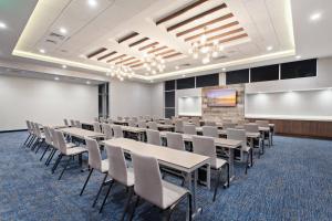 a conference room with tables and chairs and a whiteboard at SpringHill Suites by Marriott Huntington Beach Orange County in Huntington Beach
