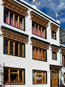 a white building with windows on the side of it at Zeejeed palace in Leh