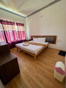 sypialnia z dużym łóżkiem i drewnianą podłogą w obiekcie Zeejeed palace w mieście Leh