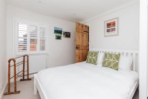 Habitación blanca con cama y ventana en The Poppies, en Henley on Thames