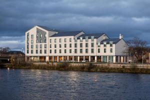印威內斯的住宿－AC Hotel by Marriott Inverness，水体旁的白色大建筑