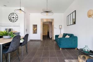 ein Wohnzimmer mit einem blauen Sofa und einem Tisch in der Unterkunft Lyon Cité-Gallo Romaine terrasse in Caluire-et-Cuire