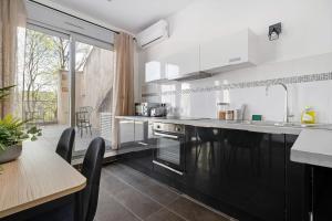 una cocina con electrodomésticos en blanco y negro y una mesa en Lyon Cité-Gallo Romaine terrasse en Caluire-et-Cuire