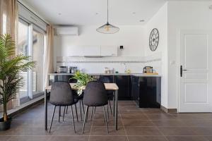 cocina con mesa y sillas en una habitación en Lyon Cité-Gallo Romaine terrasse en Caluire-et-Cuire