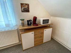 eine Mikrowelle auf einem Holzschrank in einem Zimmer in der Unterkunft Jacky & Daniel's Apartments Top 2 in Sankt Pölten