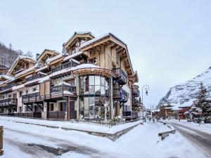 ein großes Holzgebäude im Schnee in der Unterkunft Appartement Val-d'Isère, 4 pièces, 6 personnes - FR-1-567-99 in Val dʼIsère