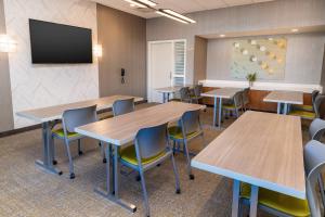 レイクフォレストにあるSpringHill Suites by Marriott Irvine Lake Forestのテーブルと椅子、薄型テレビが備わる教室です。