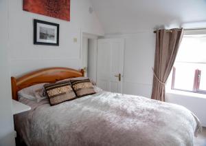 a bedroom with a large bed and a window at Sheila's Cottage Ballyheigue in Ballyheigue