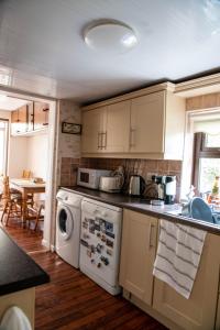 una cucina con lavandino e lavastoviglie di Sheila's Cottage Ballyheigue a Ballyheige