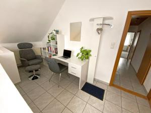 Zimmer mit einem Schreibtisch, einem Laptop und einem Stuhl in der Unterkunft Jacky & Daniel's Apartments Top 2 in Sankt Pölten